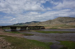 Eher untypisches Bild aus einem regenstarken Frühjahr: ein über die Ufer getretener Fluss mit unbefahrbarer Brücke unter blauem mongolischem Himmel